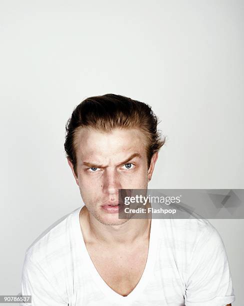 portrait of man with raised eyebrow - men confrontation stock pictures, royalty-free photos & images
