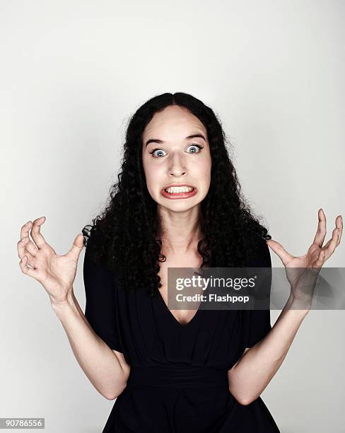 portrait of woman looking frustrated - clenching teeth stock-fotos und bilder