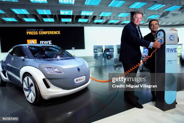 Carlos Ghosn, the President and CEO of Renault, and Juergen Grossmann, CEO of German energy giant RWE , pose next to a charging device for electric...