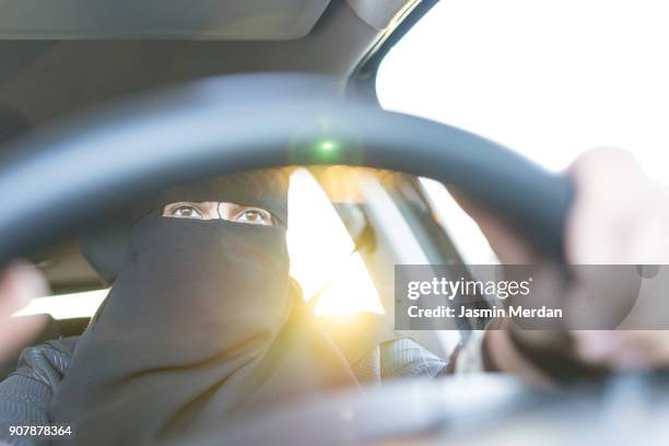 happy saudi arabian woman driving a car - saudi women driving stock-fotos und bilder