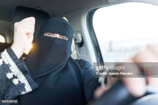 arabic muslim woman with veil and scarf driving car - burka stock pictures, royalty-free photos & images