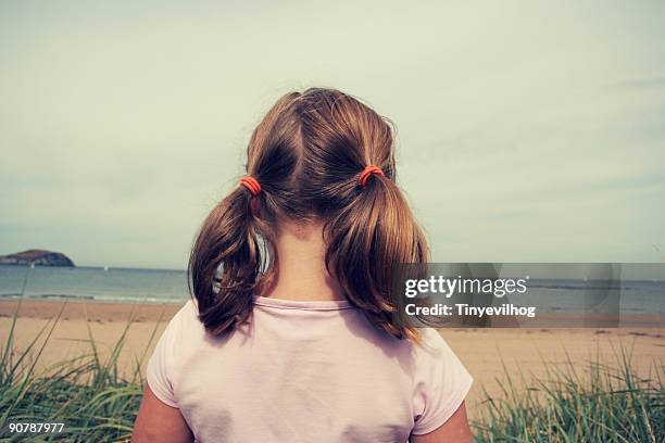 young girl on beach - haarzopf stock-fotos und bilder