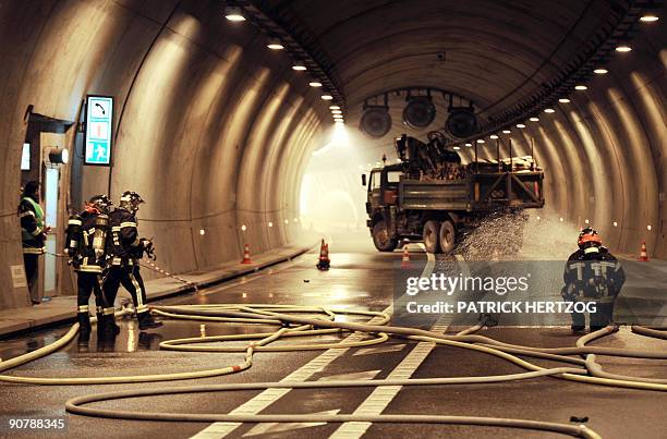 French firemen spray water in a tunnel in Schirmeck, eastern France during a security exercise involving a car and a truck transporting 19 tons of...