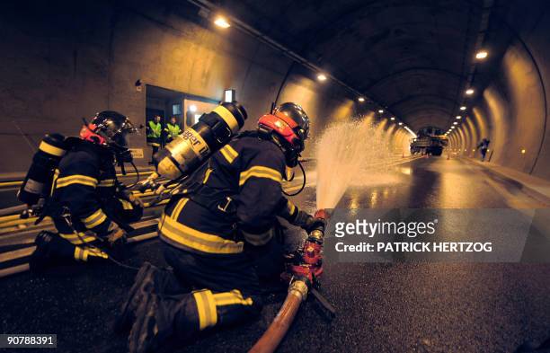 French firemen spray water in a tunnel in Schirmeck, eastern France during a security exercise involving a car and a truck transporting 19 tons of...
