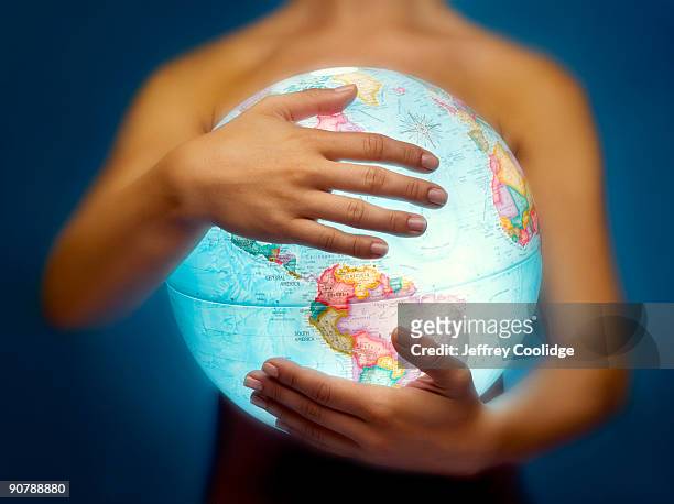 woman holding globe - frau globus stock-fotos und bilder