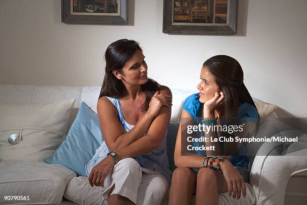 mother and teenage daughter on sofa - teenage girl club stock-fotos und bilder