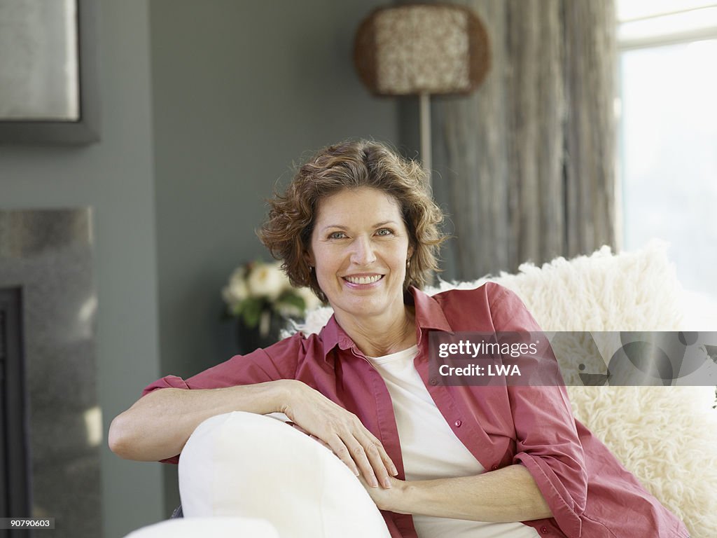 Mature Woman Sitting On Couch In Loft