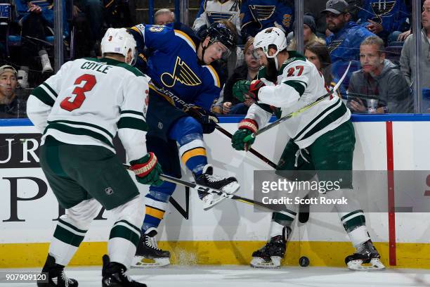Dmitrij Jaskin of the St. Louis Blues and Kyle Quincey of the Minnesota Wild battle for the puck at Scottrade Center on November 25, 2017 in St....