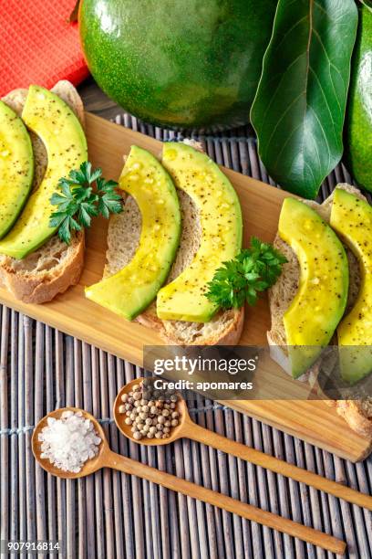 snack oder vorspeise avocadoscheiben bruschetta mit olivenöl, pfefferminze und salz - aguacates stock-fotos und bilder