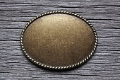 Oval Silver Buckle On Weathered Wood Surface