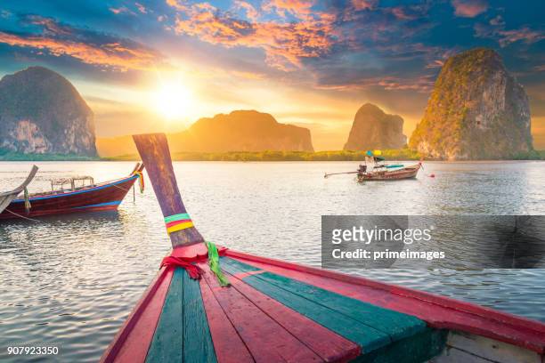 vacker solnedgång på tropiska havet med long tail-båt i south thailand - båttaxi bildbanksfoton och bilder