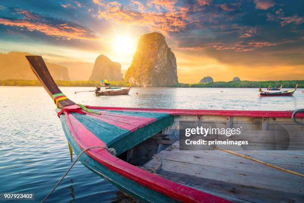 beautiful sunset at tropical sea with long tail boat in south thailand - longtail boat stock pictures, royalty-free photos & images