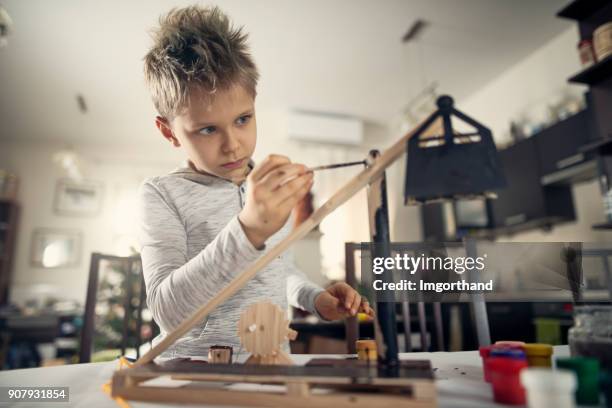 little boy painting trebuchet model - one boy stock pictures, royalty-free photos & images