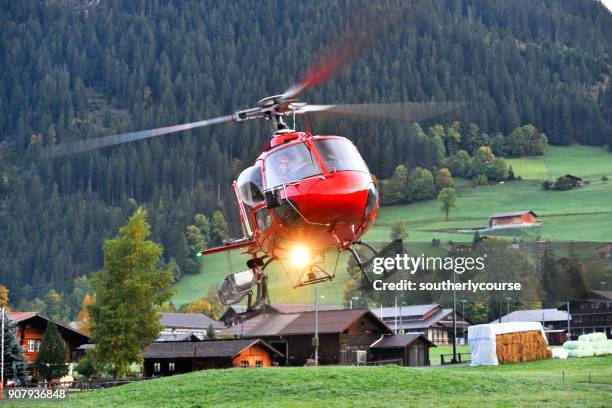 helicopter hovering over runway in rural switzerland - helicopter cockpit stock pictures, royalty-free photos & images