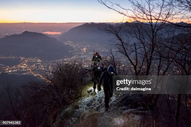 mountaineers trekking on mountain at twilight  over the city - people climbing walking mountain group stock pictures, royalty-free photos & images