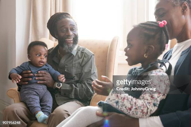 grandparents sitting with grandson and granddaughter on their laps - dreadlocks stock pictures, royalty-free photos & images