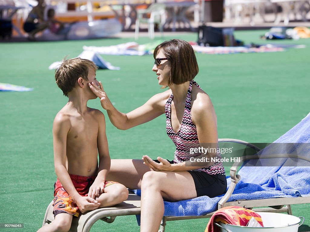 Parent applying sunscreen to chld at water park