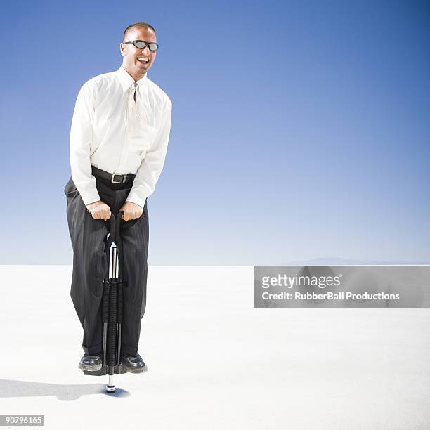 businessman on a pogo stick - pogo stick stock pictures, royalty-free photos & images