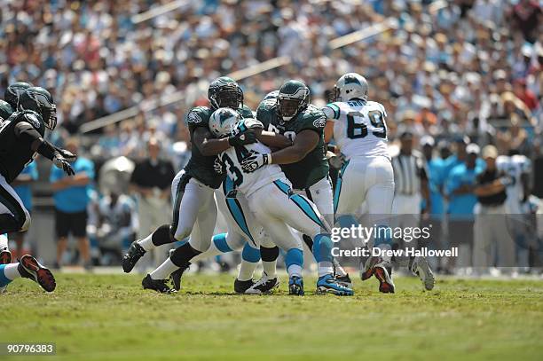 Defensive end Trent Cole and defensive tackle Mike Patterson of the Philadelphia Eagles tackle running back DeAngelo Williams of the Carolina...