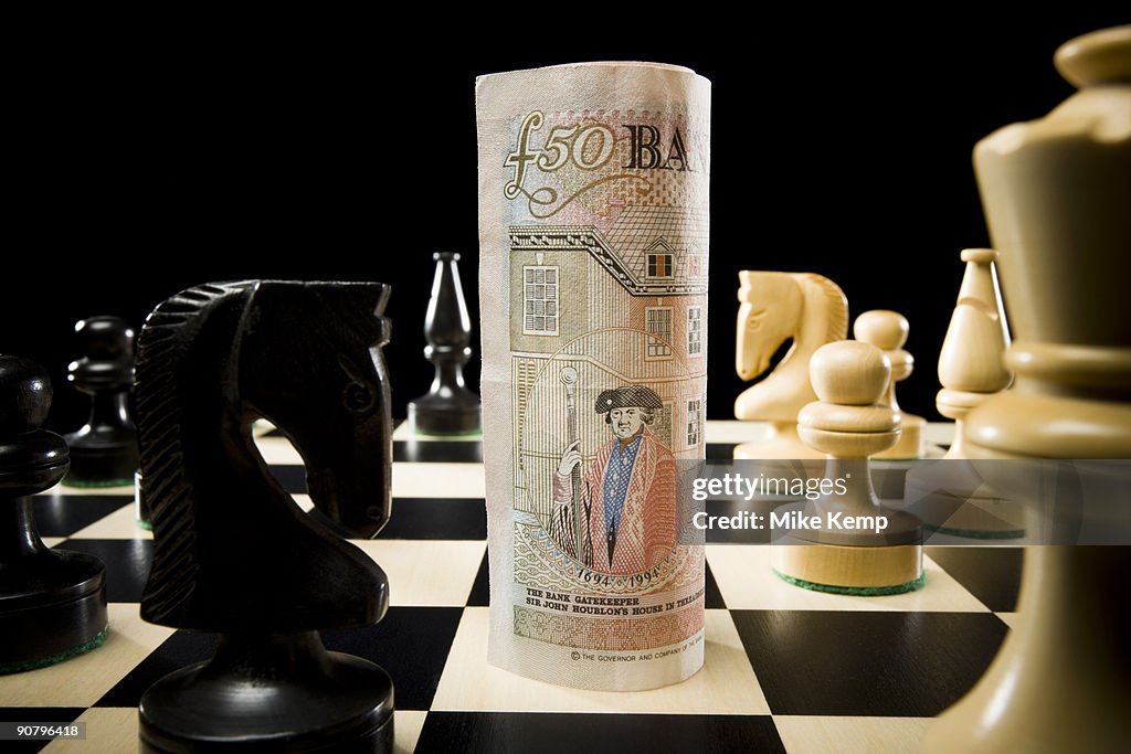 Rolled currency on a chess board