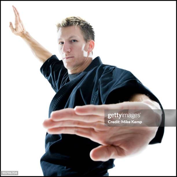 man in a black karate gi practicing martial arts - gi abbigliamento per arti marziali foto e immagini stock