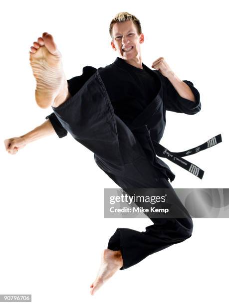 man in a black karate gi practicing martial arts - gi abbigliamento per arti marziali foto e immagini stock