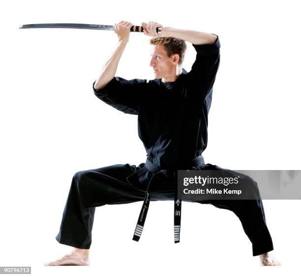man in a black karate gi practicing martial arts - gi abbigliamento per arti marziali foto e immagini stock