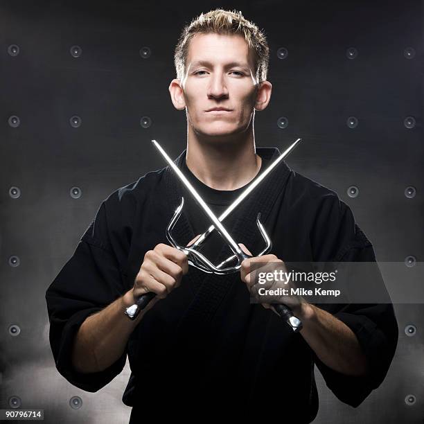 man in a black karate gi practicing martial arts - gi abbigliamento per arti marziali foto e immagini stock
