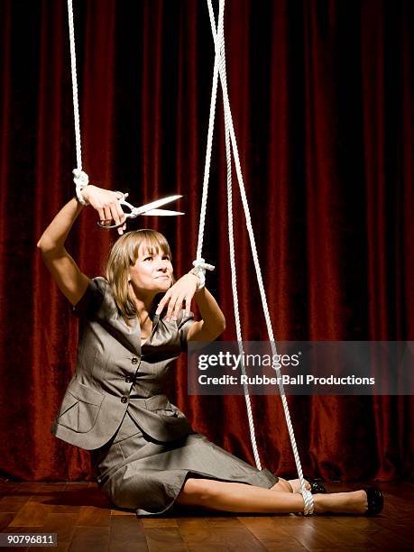 businesswoman being pulled by strings like a puppet - marionette stockfoto's en -beelden