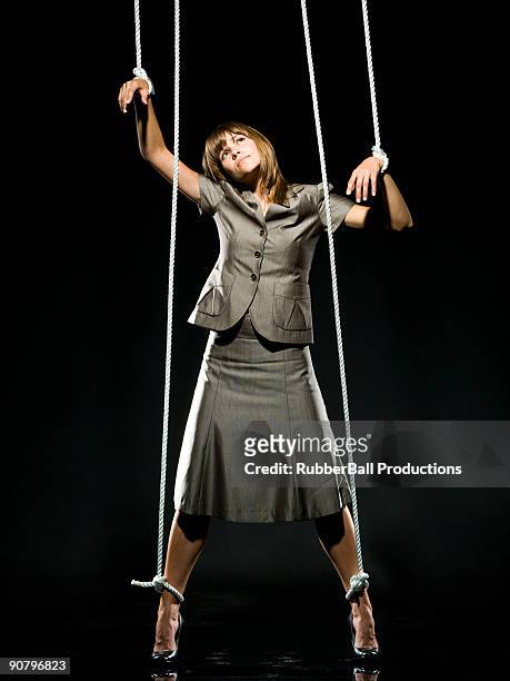 businesswoman being pulled by strings like a puppet - marionette imagens e fotografias de stock