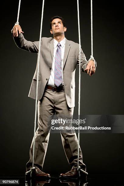 businessman being pulled by strings like a puppet - puppet on a string stock pictures, royalty-free photos & images