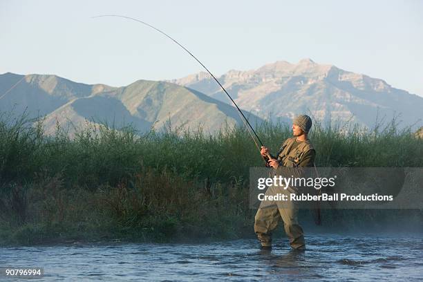 fly fisherman fishing in a mountain river - young men fishing stock pictures, royalty-free photos & images