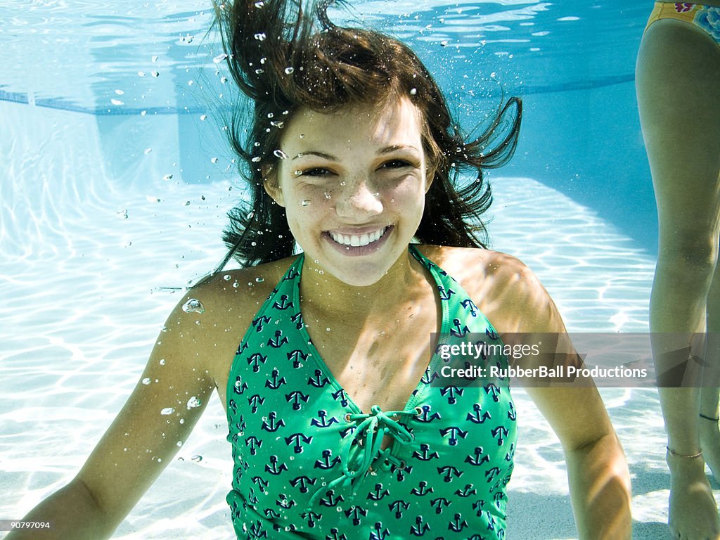 Adolescente ragazza in un costume da bagno nuoto in piscina