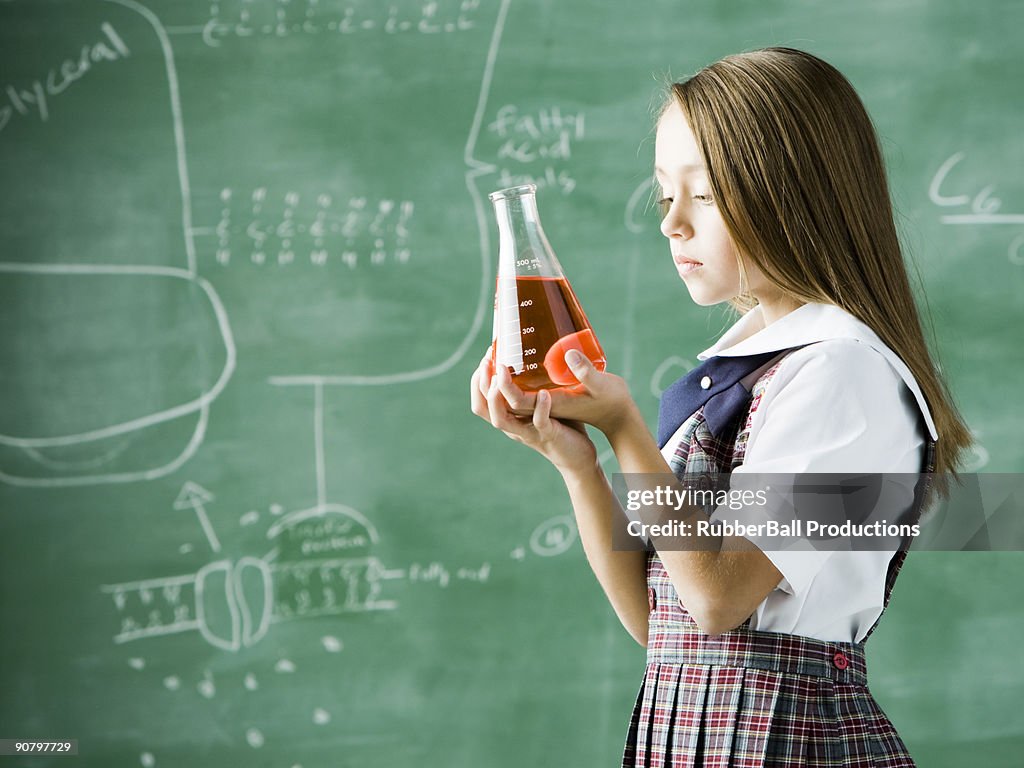 Mädchen in einem Klassenzimmer stehen vor einer Tafel mit einer erl