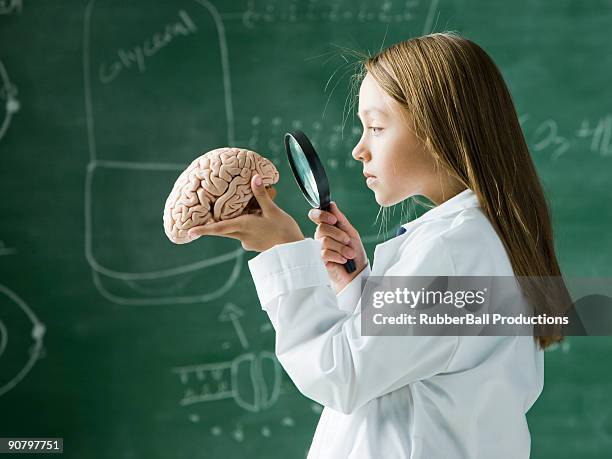 menina em uma sala de aula em pé na frente de uma chalkboard olhar - child magnifying glass imagens e fotografias de stock