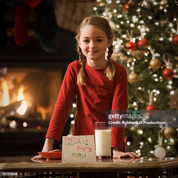girl leaving out milk and cookies for santa claus - kid with christmas tree stock pictures, royalty-free photos & images