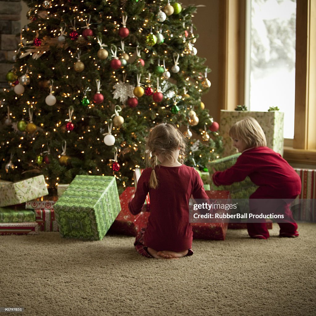 Two children opening gifts on christmas morning