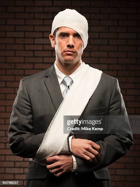 businessman with bandages on - workers compensation - fotografias e filmes do acervo