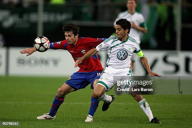 Alan Dzagoev of Moscow is challenged by Josue of Wolfsburg during the UEFA Champions League Group B match between VfL Wolfsburg and CSKA Moscow at...