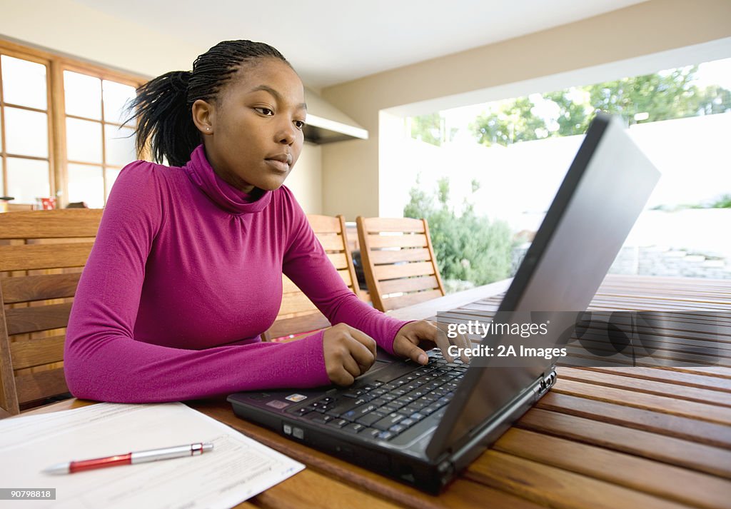 A young woman works at her laptop on the patio, Johannesburg, Gauteng Province, South Africa