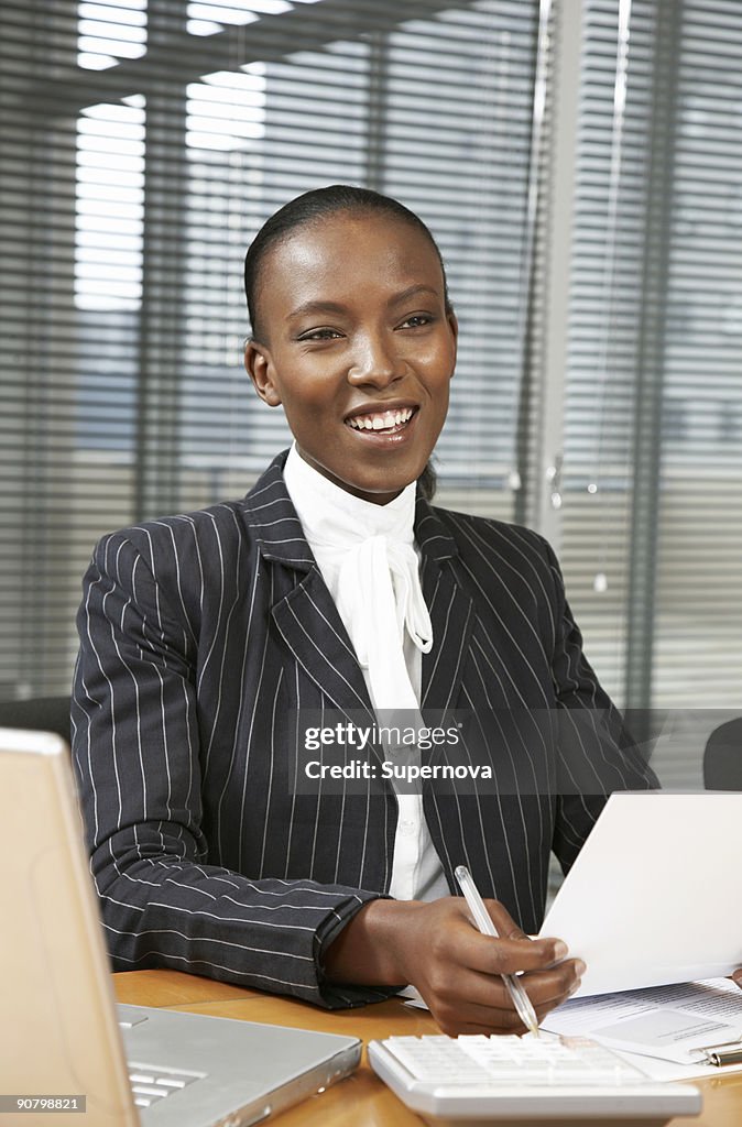 Businesswoman sitting at her desk in an office environment, Cape Town, Western Cape Province, South 