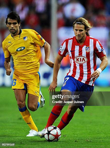 Diego Forlan of Atletico de Madrid runs with the ball ahead of Nuno Morais of APOEL FC during the Champions League group D match between Atletico...