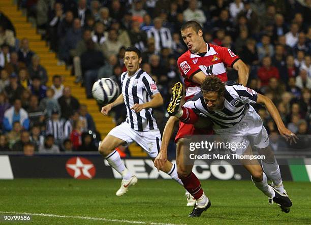 Jonas Olsson of West Bromwich Albion beats Jason Shackell of Doncaster Rovers to score his second goal during the Coca Cola Championship match...
