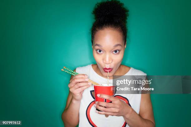 woman eating noodles - noodle foto e immagini stock