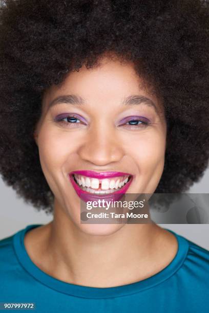 young woman with afro smiling - rosa lippenstift stock-fotos und bilder