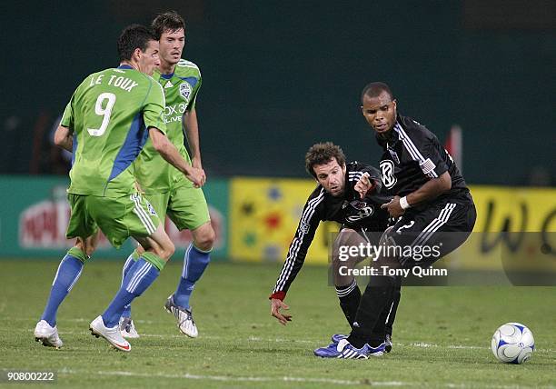 Ben Olsen and Julius James of D.C. United moves the ball away from Sebastien Le Toux and Leo Gonzalez of Seattle Sounders FC during an MLS match at...