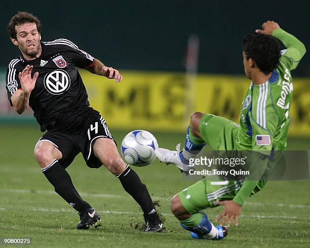 Ben Olsen of D.C. United tangles with Fredy Montero of Seattle Sounders FC during an MLS match at RFK Stadium on September 12, 2009 in Washington,...