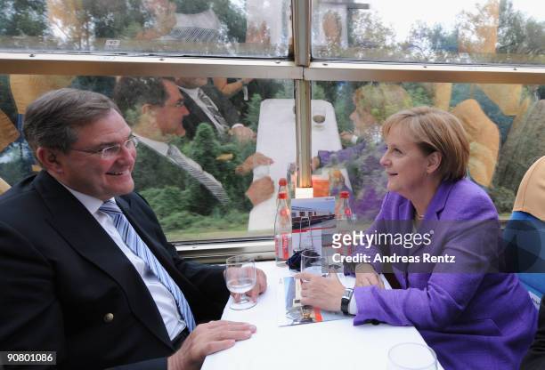 German Defence Minister Franz Josef Jung of the Christian Democratic Union and German Chancellor Angela Merkel take a seat during her campaign rally...