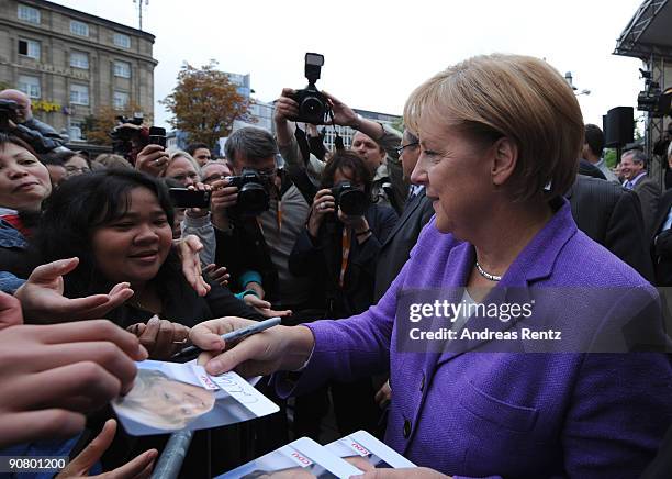 German Chancellor Angela Merkel of the Christian Democratic Union signs autographs on the first stop in Koblenz during an election campaign rally in...