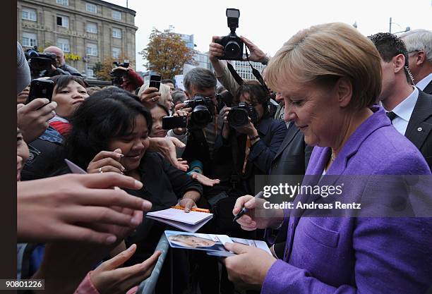 German Chancellor Angela Merkel of the Christian Democratic Union signs autographs on the first stop in Koblenz during an election campaign rally in...